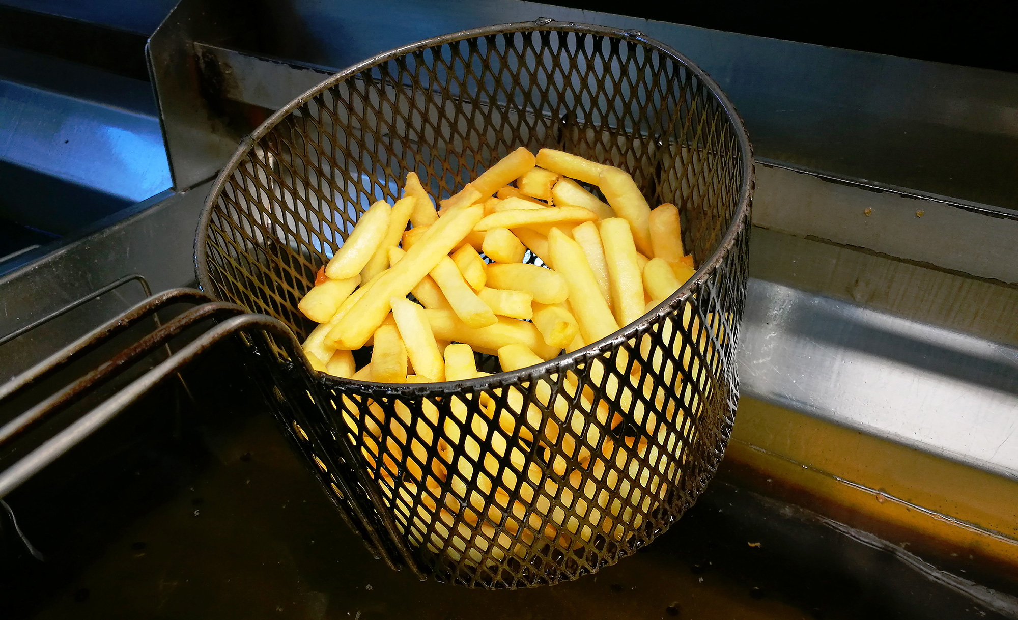 Chips fresh out of the frying draining the excess oil
